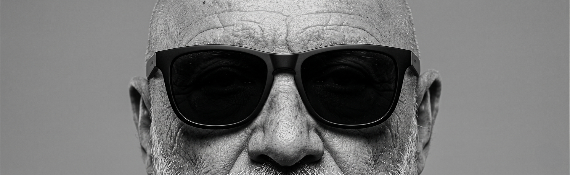 Retrato en blanco y negro de un hombre con gafas de sol, mirada firme y serena