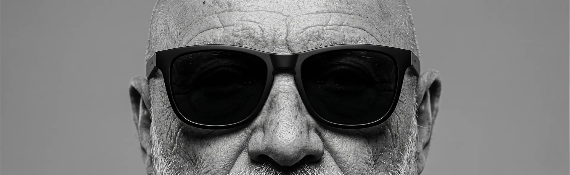 Retrato en blanco y negro de un hombre con gafas de sol, mirada firme y serena